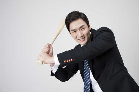Asian business man playing baseball isolated on whiteの写真素材