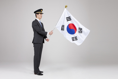 Asian police man with Korean flag isolated on whiteの写真素材
