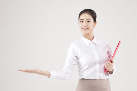 Asian female teacher putting her hand up isolated on whiteの写真素材