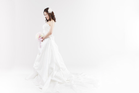 Asian beautiful bride with bouquet isolated on whiteの写真素材