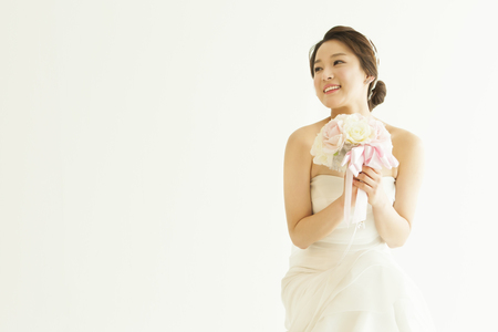 Asian beautiful bride with bouquet isolated on whiteの写真素材