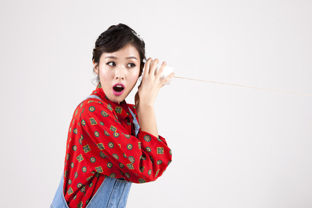 Asian retro woman with paper phone isolated on whiteの写真素材