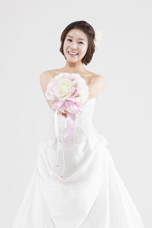 Asian beautiful bride with bouquet isolated on whiteの写真素材