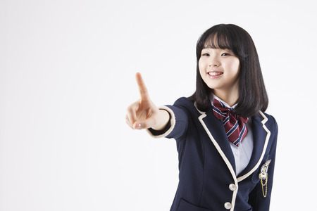 Asian female high school student with index finger up isolated on whiteのeditorial素材