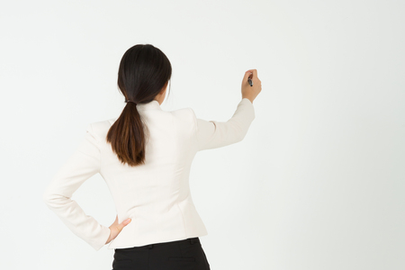 Rear view Asian business woman writing isolated on whiteの写真素材