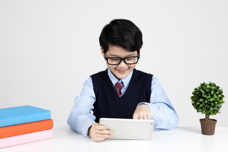 Asian elementary school boy using laptop isolated on whiteの写真素材