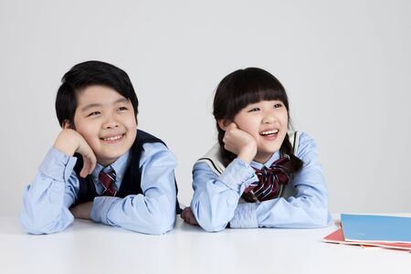Asian elementary school students looking upper isolated on whiteの写真素材