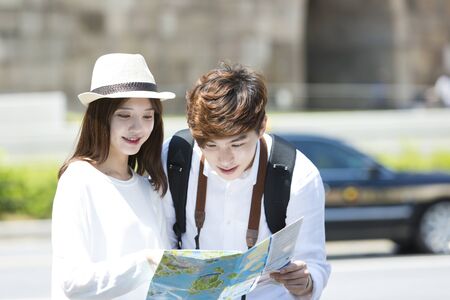 Asian tourist couple checking map