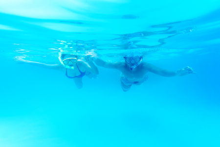 Asian happy couple in swim wear swimming in poolの写真素材