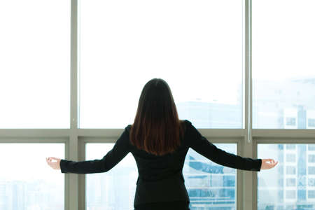 Rear view Asian business woman taking a rest in officeの写真素材