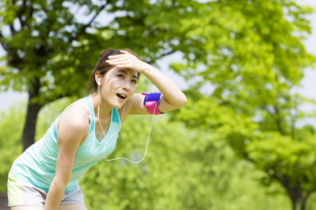 Asian sporty woman jugging with music outdoorの写真素材