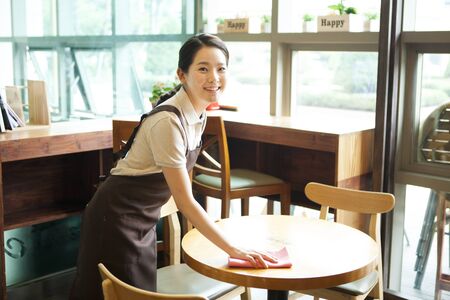 Asian female part time worker working at coffee shopの写真素材