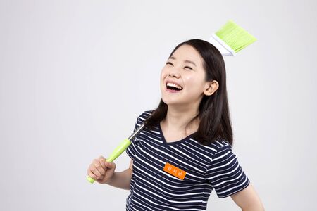 Asian female part time worker with broom isolated on whiteの写真素材