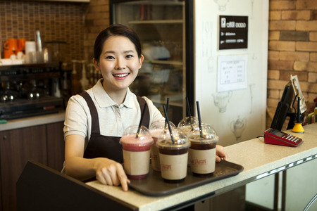Asian female part time worker working at coffee shopの写真素材