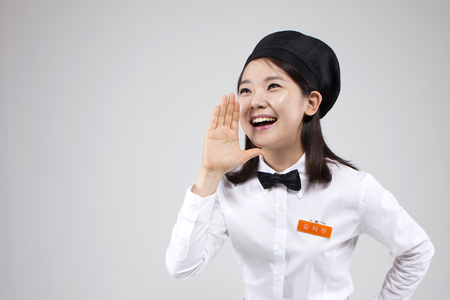 Asian female part time worker calling gesture isolated on whiteの写真素材