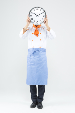 Asian male chef with clock isolated on whiteの写真素材