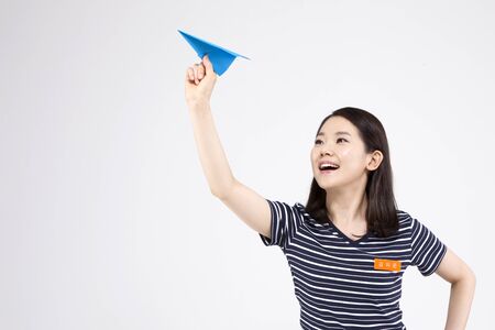 Asian female part time worker with paper airplane isolated on whiteの写真素材