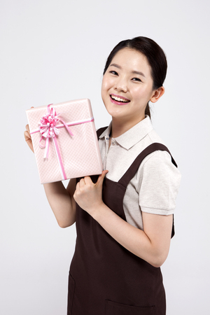 Asian female part time worker with gift isolated on whiteの写真素材