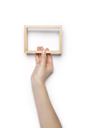 Hand Holding a wooden picture frame isolated on whiteの写真素材