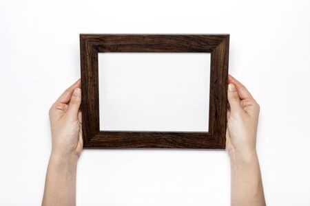 Hand Holding a wooden picture frame isolated on whiteの写真素材