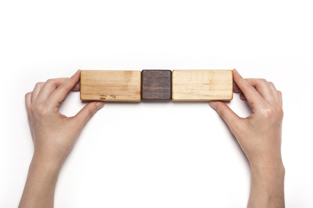 Hand assembling wooden cube puzzles isolated on whiteの写真素材