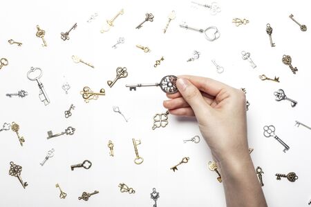 Hand holding key on different key backgroundの写真素材