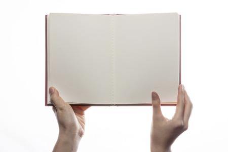 Hand holding open notebook isolated on whiteの写真素材