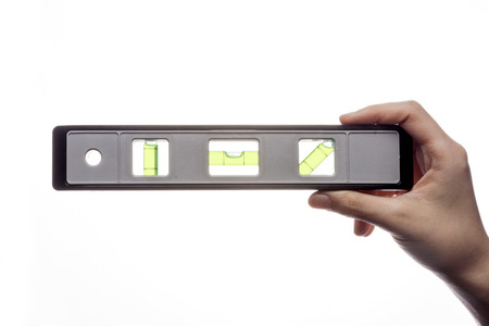 Hand holding leveler isolated on whiteの写真素材