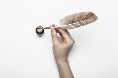 Feather quill and glass ink isolated on whiteの写真素材