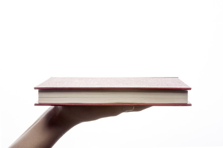 Hand holding red notebook isolated on whiteの写真素材