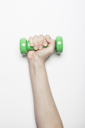 Hand holding dumbbell isolated on whiteの写真素材