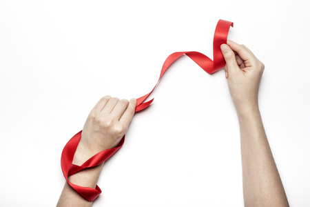 Red ribbon surround hand isolated on whiteの写真素材