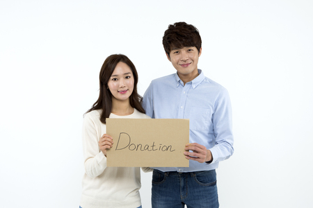 Asian couple with donation panel isolated on whiteの写真素材
