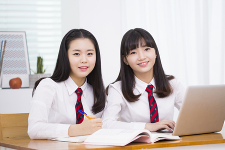 Asian female high school students using laptopの写真素材