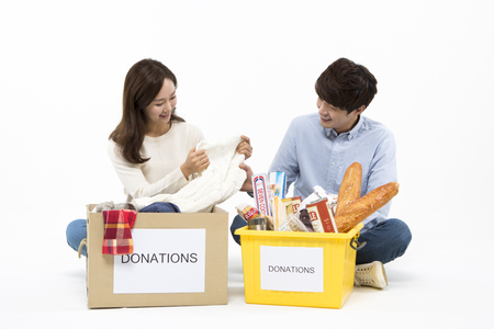 Asian couple with donation box isolated on whiteの写真素材