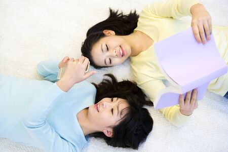 Asian female high school students reading book isolated on whiteの写真素材