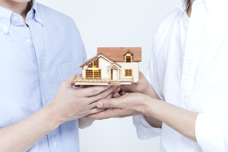 Asian father and son with miniature house isolated on whiteの写真素材