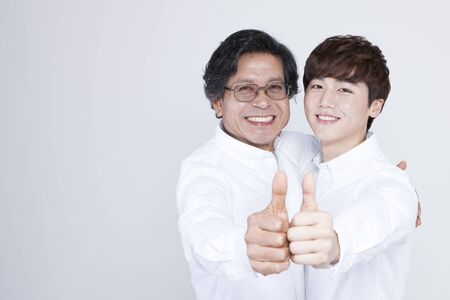 Asian father and son in thumb up gesture isolated on whiteの写真素材