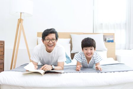 Asian grandfather and grandson using tablet pcの写真素材