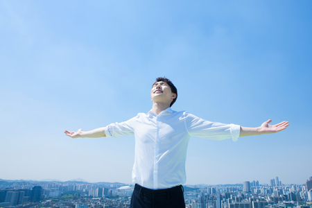 Asian man in suit feel freedom with blue skyの写真素材