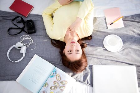 Asian beautiful woman lying back with itemsの写真素材