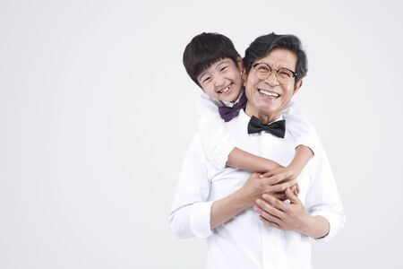 Asian grandfather and grandson looking happy isolated on whiteの写真素材