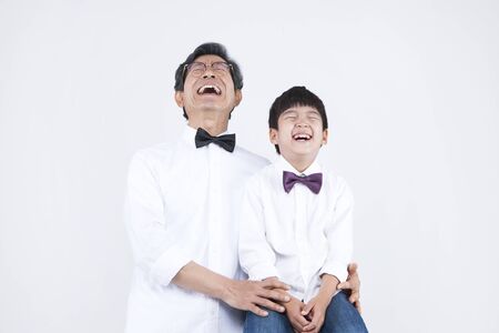 Asian grandfather and grandson with smile isolated on whiteの写真素材