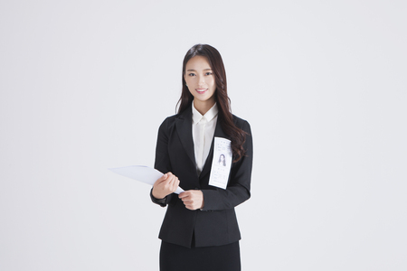 Asian woman in suit with document isolated on whiteの写真素材