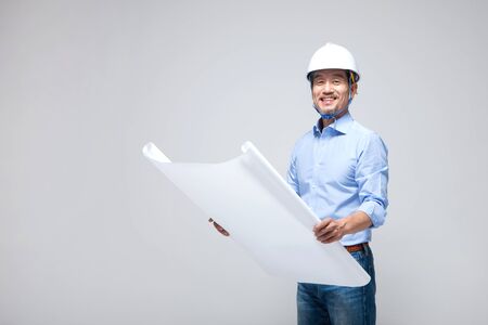 Asian man engineer with blueprint isolated on whiteの写真素材