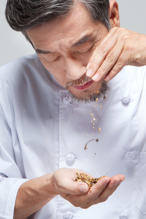 Asian man chef with ingredient isolated on whiteの写真素材