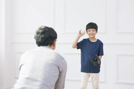 Asian grandfather and grandson playing catchの写真素材