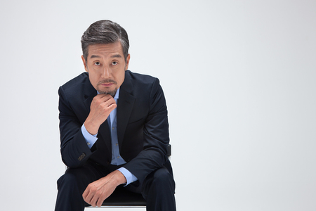 Asian man in suit looking confident isolated on whiteの写真素材