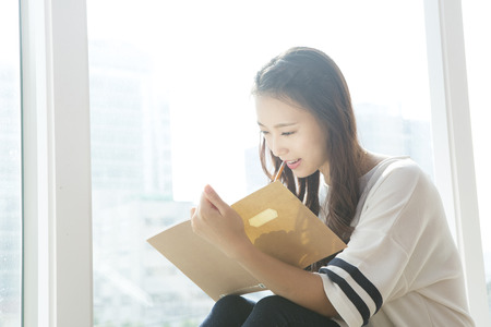Asian woman writing somethingの写真素材