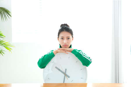 Asian woman with clockの写真素材